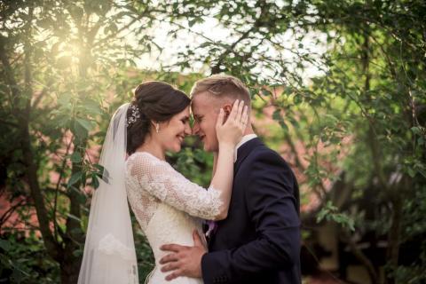 A bride and groom in front of trees