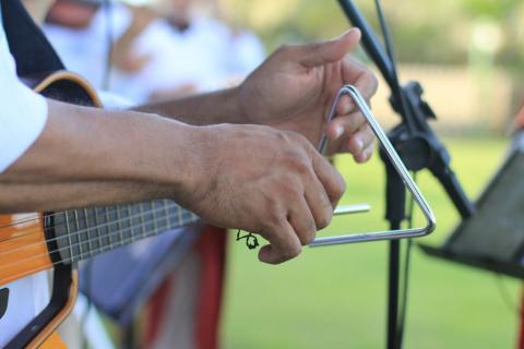 A guitarist playing triangle 