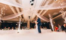 A bride and groom dancing surrounded by sparklers 